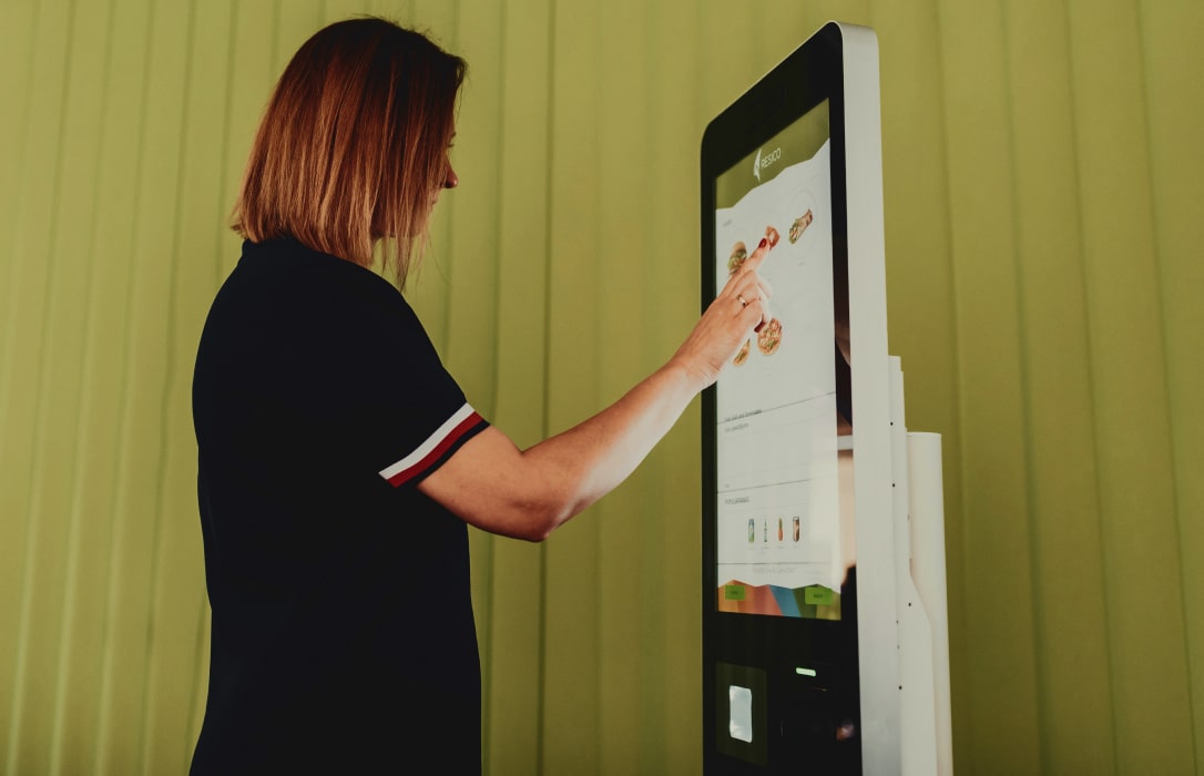 customer interacting with self service kiosk